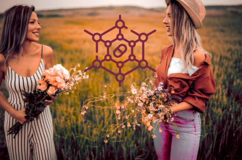 Deux femmes souriantes dans un champ avec des bouquest de fleurs illustrant la nutrition féminine